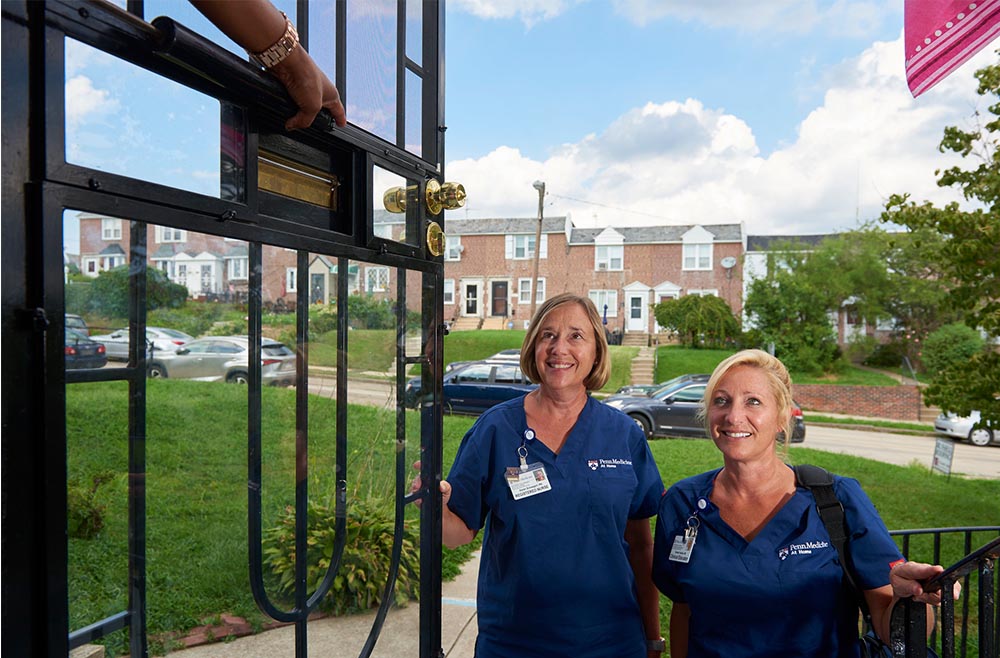 Two female clinicians visiting patient at home